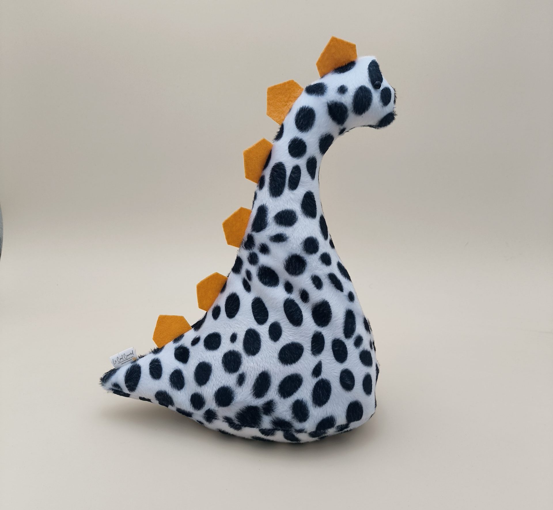 Cale-porte dinosaure - fausse fourrure dalmation avec ses plaques jaune
